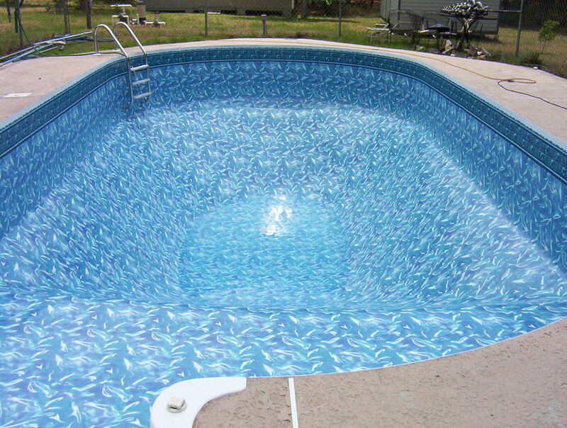 An Oval Pool Area With a White and Blue Marble Pattern