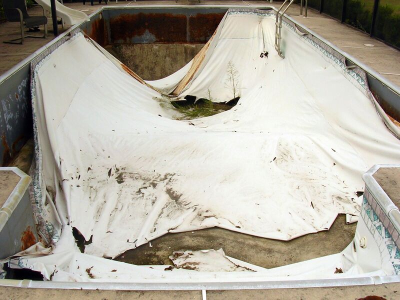 A Dried and Molded Pool With White Cover
