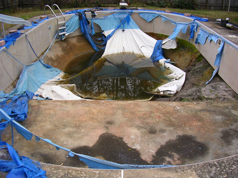 A Long Oval Pool Dirty With Torn Covers Before Cleaning