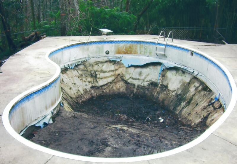 A Kidney Shaped Pool With Dirt and Mud Traces
